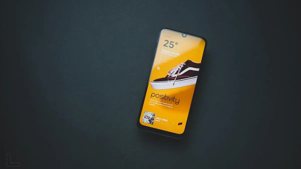Smartphone mit gelbem Bildschirm und Sneaker-Motiv auf dunklem Untergrund